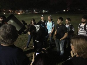 Estudiantes y miembros de la comunidad mirando a través del telescopio durante la observación nocturna del programa de ISMuL.